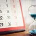 Hour glass and calendar concept for time slipping away for important appointment date, schedule and deadline