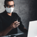 Un hombre trabaja con mascarilla para protegerse del coronavirus. Fuente: serbogachuk/ Envato Elements.