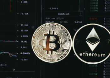 Monedas de Bitcoin y Ethereum sobre pantalla con información de mercado. Fuente: Doughnutew / pxhere.com