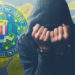 Hacker esposado oculta su rostro con logo del FBI y monedas de bitcoin cayendo en el fondo. Composición por CriptoNoticias. FBI / wikipedia.org; katemangostar / freepik.com; stevanovicigor / elements.envato.com.