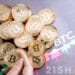 Mano sosteniendo moneda de Bitcoin con monedas de bitcoin apiladas sobre superficie con gráfico de precio con logo de 21Shares. Composición por CriptoNoticias. 21shares / 21shares.com; bitcointere / pxhere.com; avanti_photo / elements.envato.com.