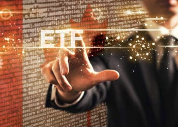 Hombre haciendo "click" a ETF y de fondo la bandera de Canadá.