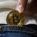 Metiendo en el bolsillo del pantalón un bitcoin