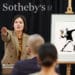 Subasta de obra de Banksy, persona ofertando en bitcoin y logo de Sotheby's al fondo.