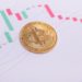 Moneda Bitcoin sobre gráfico de precio en descenso