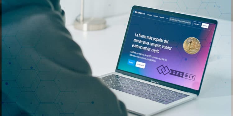 Persona revisando blockchain.com en laptop.