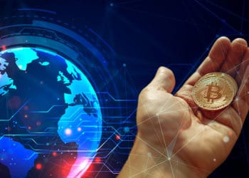 Mapa mundi y mano sosteniendo bitcoin.