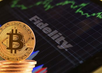 Tablet con logo de Fidelity y bitcoins.