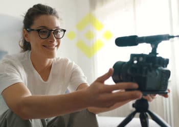 Mujer grabándose y logo de binance.