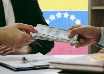 Intercambio de dólares con bandera de Venezuela al fondo y logos de Binance P2P.