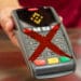 Medio de pago con logo de Binance y X encima. Bandera de Reino Unido al fondo.