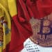 BTC sobre documento contable y bandera de España.