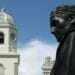 Busto de Simón Bolívar con campanario detrás.