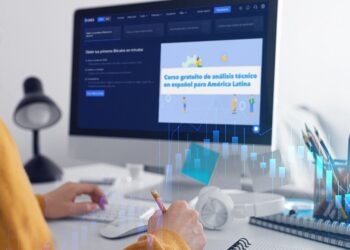 Mujer frente a pantalla de computador en escritorio