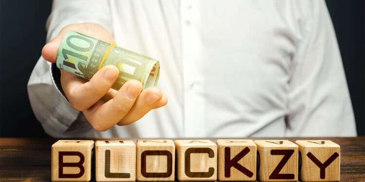 Logo de Blockzy en cubos de madera con hombre entregando billetes de euro con logo de Bitinka en camisa. Composición por CriptoNoticias. BitInka / bitinka.com; Blockzy / blockzy.com; twenty20photos / elements.envato.com.