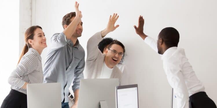 Grupo de compañeros de trabajo celebrando el éxito.