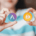 Manos sosteniendo dos criptomonedas, Aave y DAI.