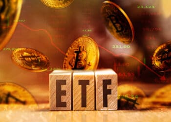 Cubos con la sigla ETF acompañados de unos bitcoins cayendo.