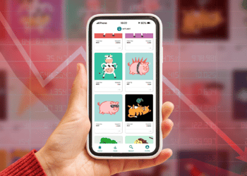 Volumen de ventas en rojo y mano sosteniendo teléfono con NFT