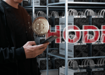 hombre sostiene teléfono con bitcoin y granja de minería de bitcoin en el fondo