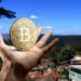 Santa Lucía, Honduras, y mano con Bitcoin.