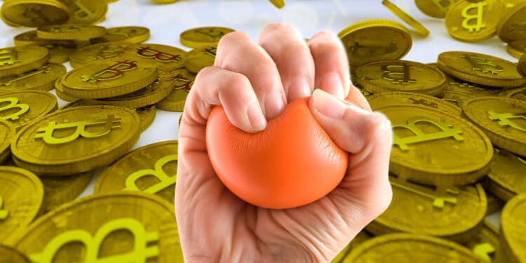 mano aprieta pelota anti estres con monedas de bitcoin en fondo