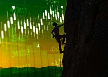 hombre escalando pared con gráfico de precio en el fondo