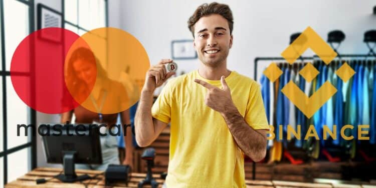 Joven sosteniendo moneda de bitcoin en tienda de ropa con logos de Binance y Mastercard en el fondo