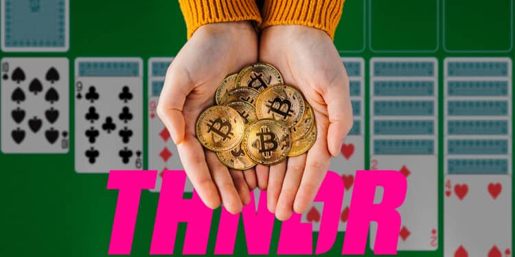 mano sostiene monedas de bitcoin con juego de solitario en el fondo