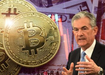 Jerome Powell junto a monedas de bitcoin sobre billetes de dólares con gráfico bajista superpuesto