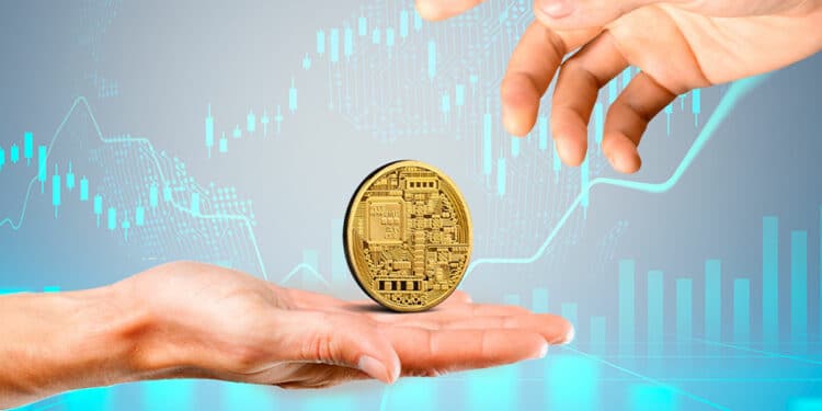 Una criptomoneda junto a unas manos y gráficos.