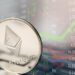 moneda de ethereum con gráfico de precio en el fondo