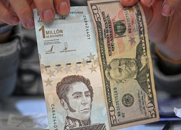 persona sostiene billete de un millón de bolívares junto a billete de 50 dólares