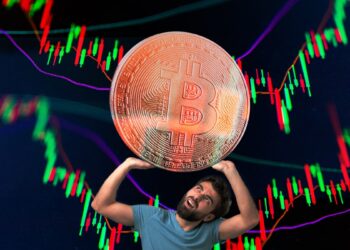 hombre sostiene peso de moneda de bitcoin con gráficos de precio en el fondo