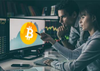 Traders mirando btc en pantalla