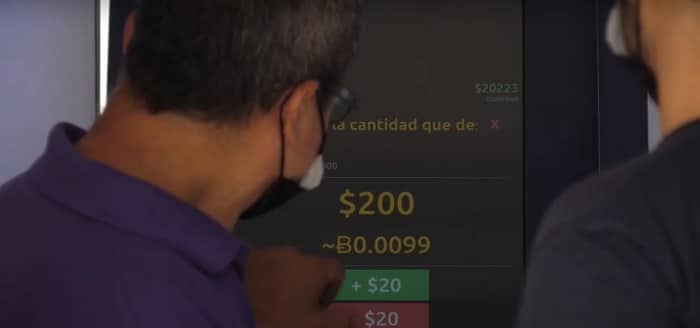 persona verificando precio de bitcoin en cajero en el salvador