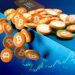 monedas de bitcoin cayendo del borde de una mesa con gráficos de exchange