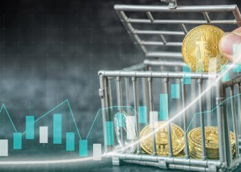 mano sostiene moneda de bitcoin sobre jaula con monedas de bitcoin y gráfico creciente superpuesto