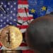 Bitcoin junto a la bandera de Estados Unidos y Europa.