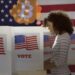 mujer pensando en bitcoin en caina de votación en Estados Unidos