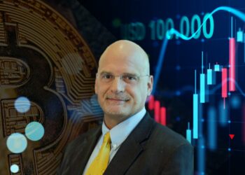 Mike McGlone entre moneda de bitcoin y gráfico de precio creciente con marca de USD 100.000 en el fondo