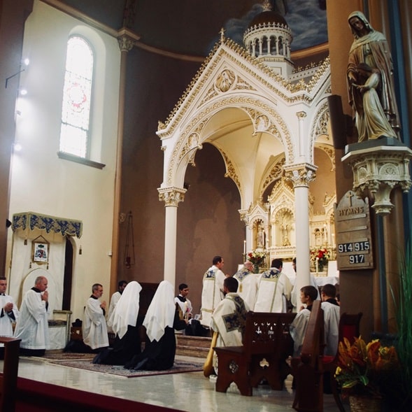 monjas y sacerdotes en misa en la iglesia Benedictas de Maria