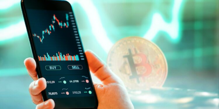 persona sostiene teléfono móvil con plataforma de exchange de criptomonedas en pantalla con bitcoin y gráfco de precio en verde en el fondo