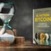 Reloj de arena con monedas y libro de The Bitcoin Standard