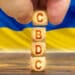 Cubos de madera con letras CBDC y fondo de bandera de Ucrania