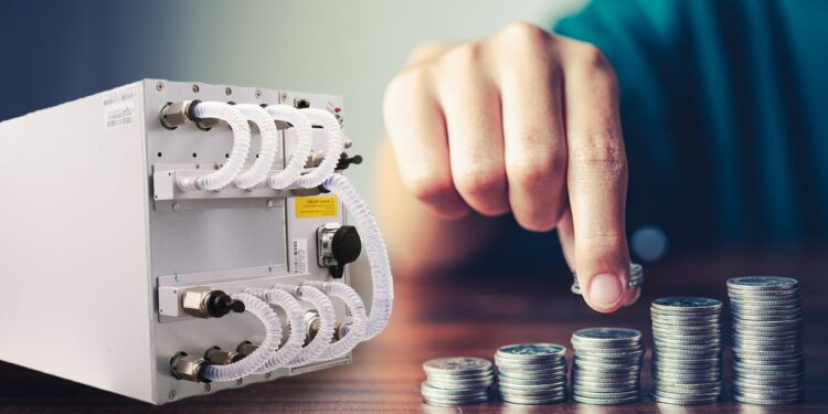 minero asic Antminer S19 XP Hyd de Bitmain, junto a mano apilando monedas