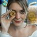 mujer sosteniendo moneda de bitcoin frente a su cara con monedas de stablecoins y bandera de argentina en el fondo