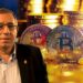 Carlos Maslatón junto con monedas de bitcoin y monedas apiladas en el fondo