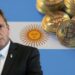 Sergio Massa junto a monedas de bitcoin apiladas sobre bandera de Argentina