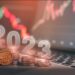 criptomoneda apoyada en monedas apiladas con 2023 superpuesto y gráficos de precio bajista en el fondo
